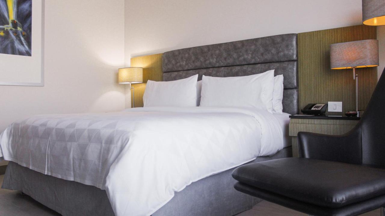 Holiday Inn Bucaramanga Cacique By Ihg Eksteriør billede A bed with a duvet